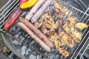 Fried sausages, chicken wings and grilled peppers.