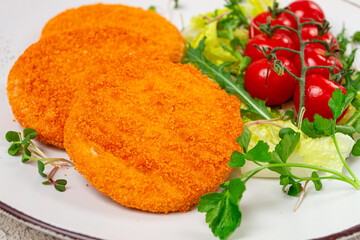 crispy fried fish cutlets, fish burgers, on a white plate, with fresh lettuce leaves, arugula and cherry tomatoes, homemade, no people,