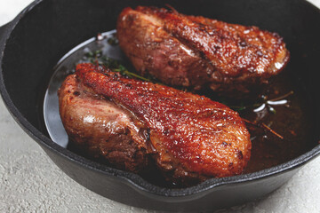 roast duck breast, in a frying pan, with spices and herbs, close-up, no people,