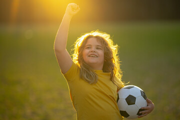 Child playing soccer. Kid boy kicking a football on the grass. Kid running with a soccer ball. Playful children enjoying a football game. Kids soccer match. Kid playing soccer kicking a ball.