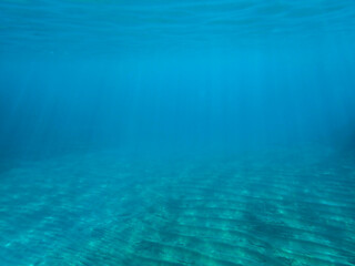 Light filtering down through blue water. Underwater sunlight in deep sea. Light viewed from blue abyss. Underwater sunlight shining deep with ripples on wave surface ocean ray, Under water background.