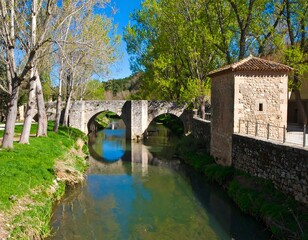 Fototapeta premium Old stone bridge over a calm river