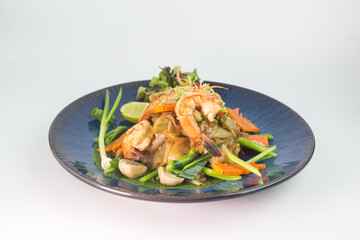Stir-fried Rice Noodles with Soy Sauce and Seafood Which consists of squid and shrimp on white background , Thai Style food