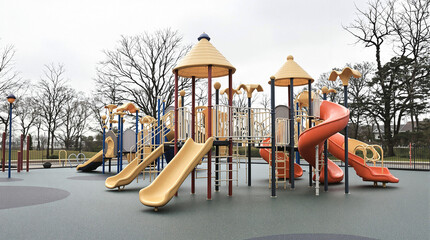 Modern and Colorful Empty Outdoor Playground with Slides and Climbing Structures in a Public Park on a Cloudy Day, Ready for Children's Recreation