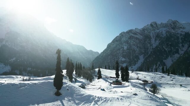 Cinematic drone shot of Thajiwas glacier region during winter, showing snow-laden slopes merging with the white meadows below.