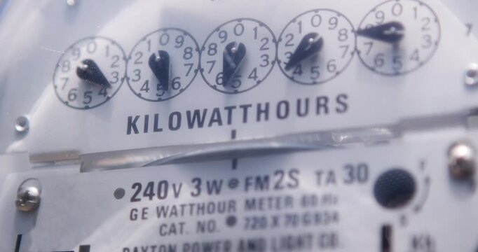 Electricity meter reader on side of house with mechanical dials 4k