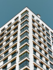 Fototapeta premium Building facade in metropolitan neighborhood. Modern concrete multistory architecture with window