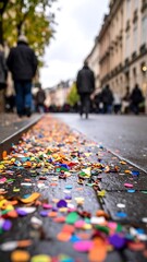 Obraz premium Colorful confetti strewn on a city street. Pedestrians in the distance