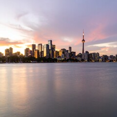 Obraz premium City skyline at sunset with glowing lights and dramatic sky