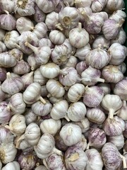 Garlic bulbs piled in abundance as a background showcasing fresh produce and healthy eating