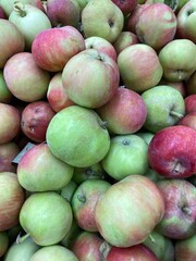 Fresh apples in varying shades of red and green create a vibrant harvest background