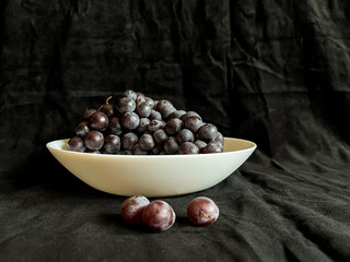 Grapes, Fresh grapes with water drops on a dark background. Still life with natural fruits in a bow