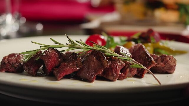 Beef angus steak in restaurant, close up Pieces of hot ribeye steak served on the wooden board. Medium steak slices with blood, salt and pepper in fancy meat cafe. 