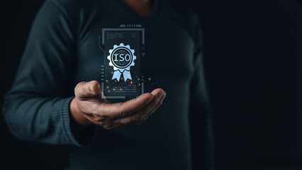 A person holds a glowing holographic certificate featuring an ISO badge, symbolizing international standards, quality assurance, compliance, and certification in modern digital business practices.