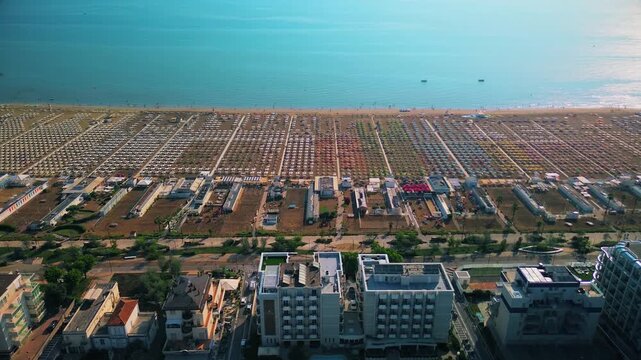 Aerial view of large equipped sandy beaches. Umbrellas and sun loungers for vacationers by the sea. Vacation on the Adriatic Sea. Ferris wheel. Traveling on Europe. Vacation in Italy Rimini 17.08.2025