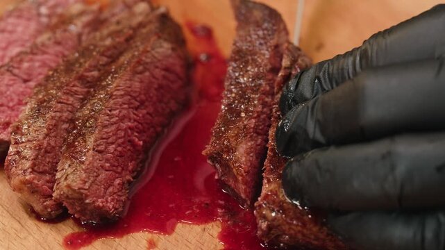 Beef angus steak in restaurant, close up Pieces of hot ribeye steak served on the wooden board. Medium steak slices with blood, salt and pepper in fancy meat cafe. 