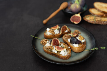 Horizontal Front View of Three Fig and Goat Cheese Toasts on Dark Background