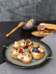 Vertical Top View of Three Fig and Goat Cheese Toasts on Dark Background