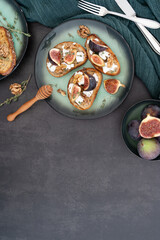 Vertical Display of Three Fig Toasts with Goat Cheese and Honey on Green Plate