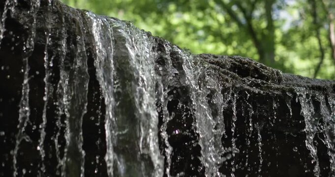 Stream of water falling over rock edge slow motion 2k