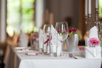 Elegantly decorated tables with colorful flowers at a wedding. Close-ups of glasses, flowers, and decorations. Symbolic of a wedding, soft background.