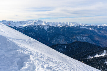 A beautiful snowy slope featuring majestic mountains in the background
