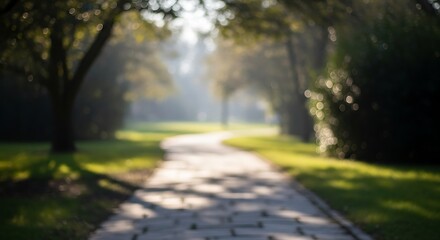 Fototapeta premium A blurred and dreamy path winds through a park, framed by trees and bathed in soft sunlight, creating a serene and inviting scene for a peaceful stroll