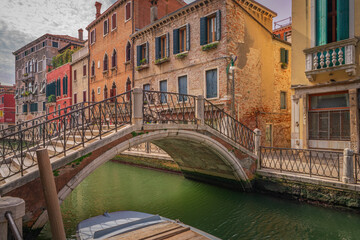 Venetian bridge over canal with colorful houses