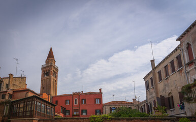 Naklejka premium Venetian brick bell tower seen from canal and street