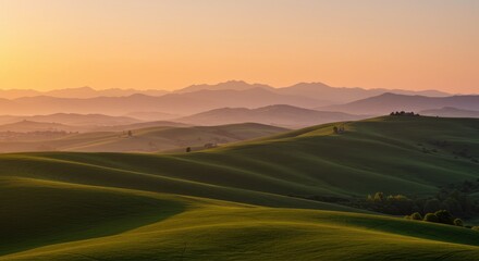 Rolling green hills and mountains at sunset with golden light