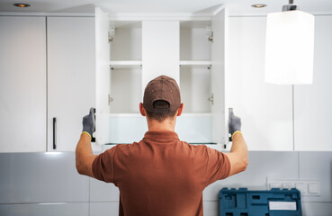 Cabinet Installer Working in a Modern Kitchen During Daylight Hours