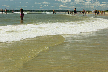 Beachgoers Enjoying Turquoise Ocean. People playing Summer Fun Coastline of sandy beach