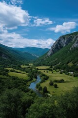Scenic mountain valley with river and lush greenery under blue sky
