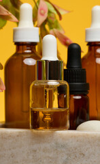 Glass dropper bottle with a silver cap and a white dropper dripping amber liquid