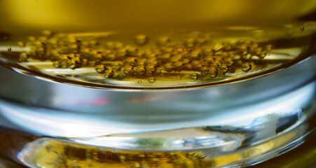 Macro close-up of beer bubbles at bottom of glass