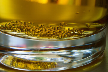 Macro close-up of beer bubbles at bottom of glass