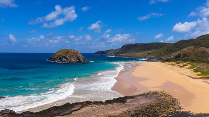 Vista panorâmica da Praia do Leão em Fernando de Noronha, com mar azul intenso, ondas fortes e...
