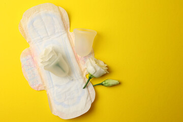Eco-friendly menstrual cup and other feminine hygiene products on a bright background