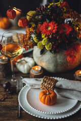 Atmospheric autumn elegant beautiful table setting with pumpkins for a wedding or thanksgiving family celebration. Fall decoration countryside rustic style, cozy home atmosphere , candles, wine