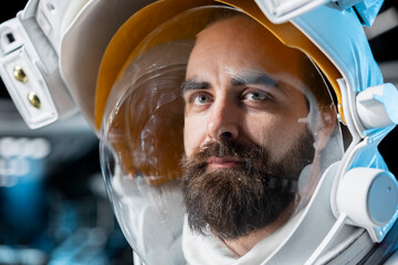 Close up of cosmonaut wearing helmet flying in futuristic starship during cosmic journey. Astronaut wearing equipment preparing for mission launch, conducting safety checks during space travel