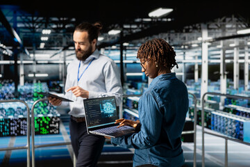 Black woman engineer overseeing code debugging tech on laptop, programming AI deep learning script for datasets automation and innovation in server hub. Industrial platform engineering.
