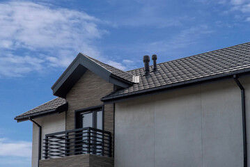 Composite roof tile with ventilation pipes on modern house facade