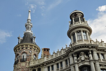 Fototapeta premium Close-up view of two richly ornamented towers in central Madrid, showcasing the city's architectural grandeur with baroque and neoclassical details