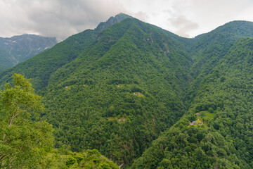 Fototapeta premium stunning view of rolling green mountains dotted with quaint houses, capturing the serene essence of Switzerland's breathtaking landscapes