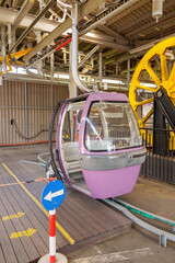colorful cable car waiting at the station, ready to take passengers high above the stunning Swiss Alps, surrounded by scenic mountain views