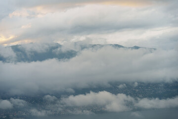 Fototapeta premium mysterious fog enveloping the serene mountains of switzerland, revealing a picturesque lakeside view