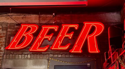 Bright red neon beer sign is displayed at a neighborhood bar 