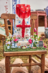 Tall blue and white ceramic vase with intricate floral patterns, filled with green wild grass, placed outdoors in a rustic setting. traditional pottery