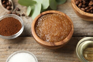 Natural body scrub and ingredients on wooden table, closeup