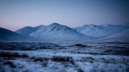 A tranquil winter landscape showcases snow-capped mountain ranges under a serene twilight sky.
